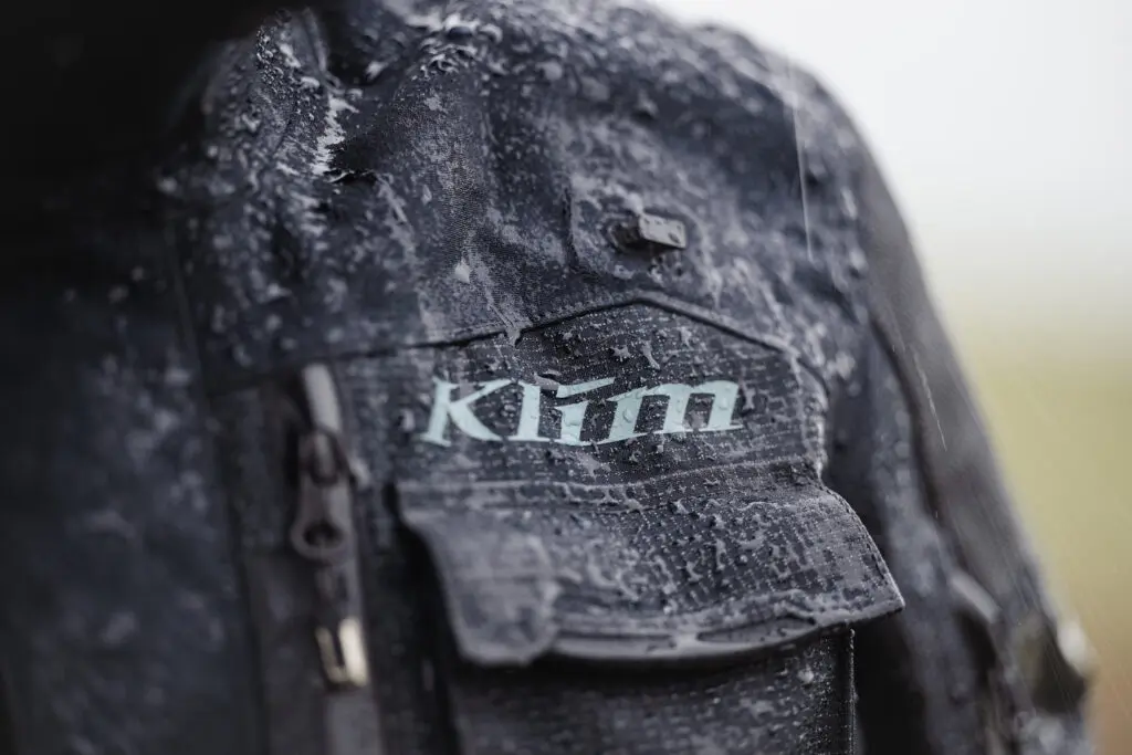 Klant past een KLIM Badlands-pak in de showroom van ABG Shop Rotterdam